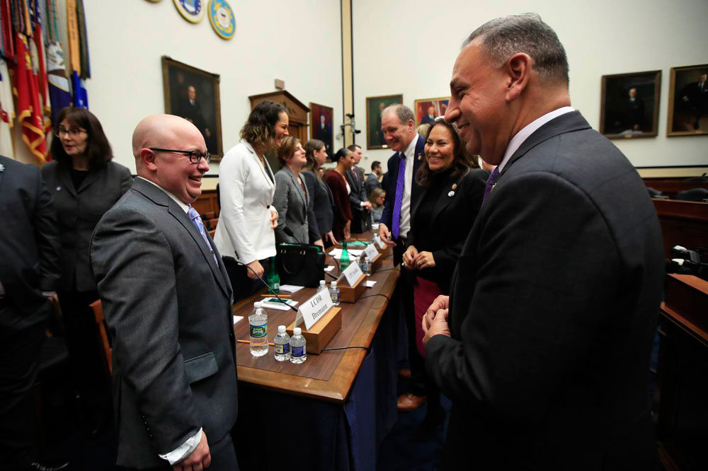 Gil Cisneros, right, talks to Navy Lt. Cmdr. Blake Dremann